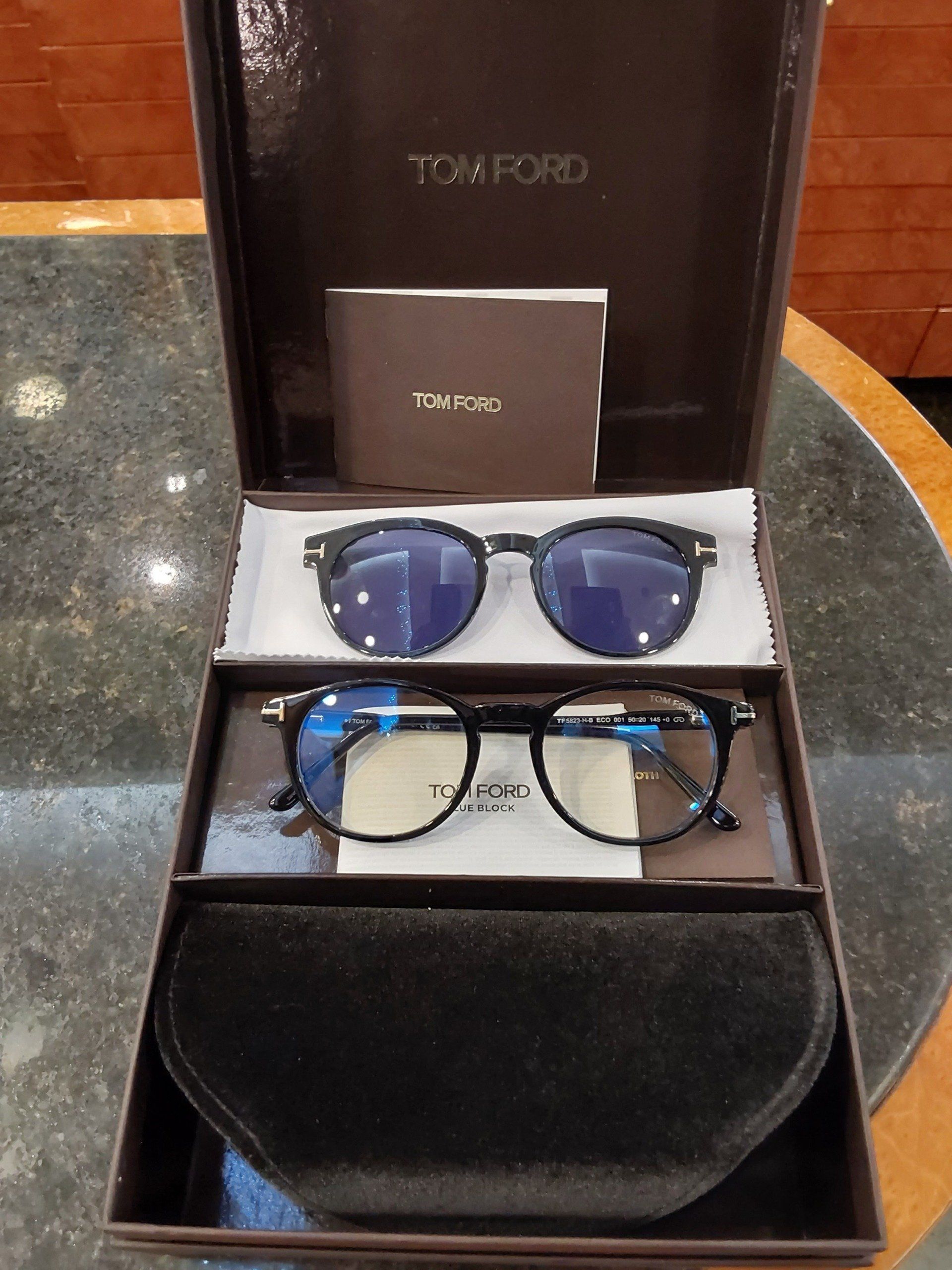 Due paia di occhiali da vista Tom Ford in una scatola aperta con custodia, cartoncino e panno per la pulizia.