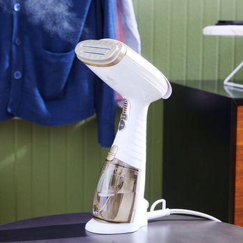 A white handheld steamer is sitting on a table