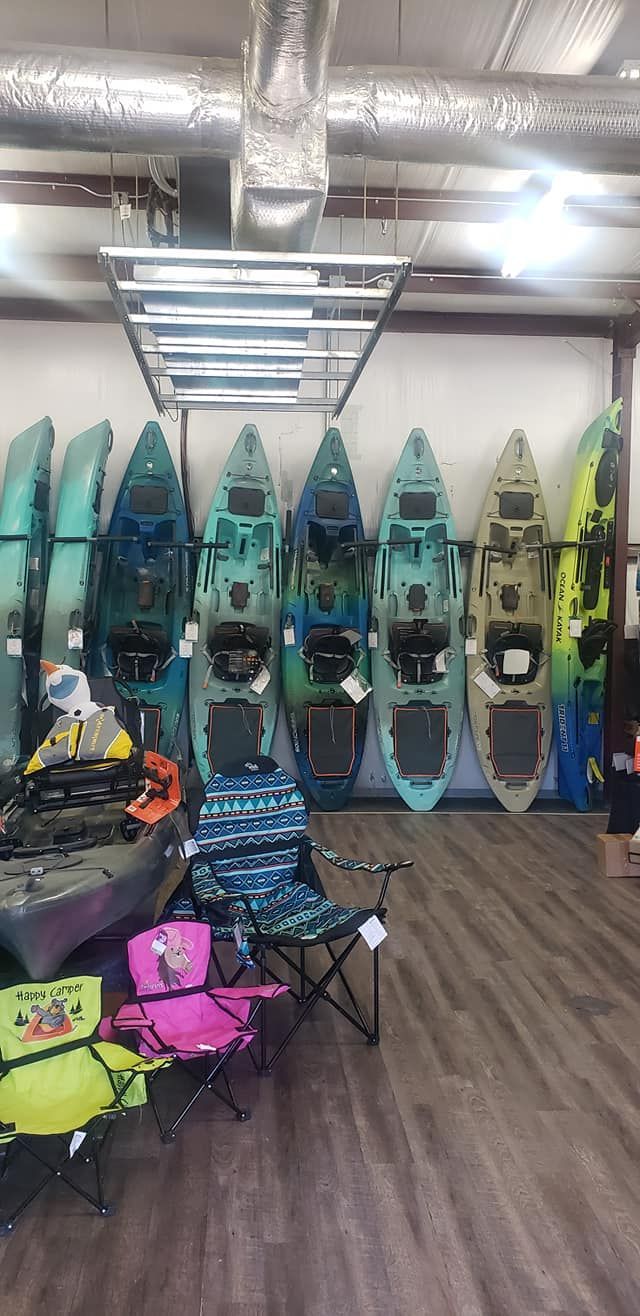 a store filled with lots of kayaks and chairs .