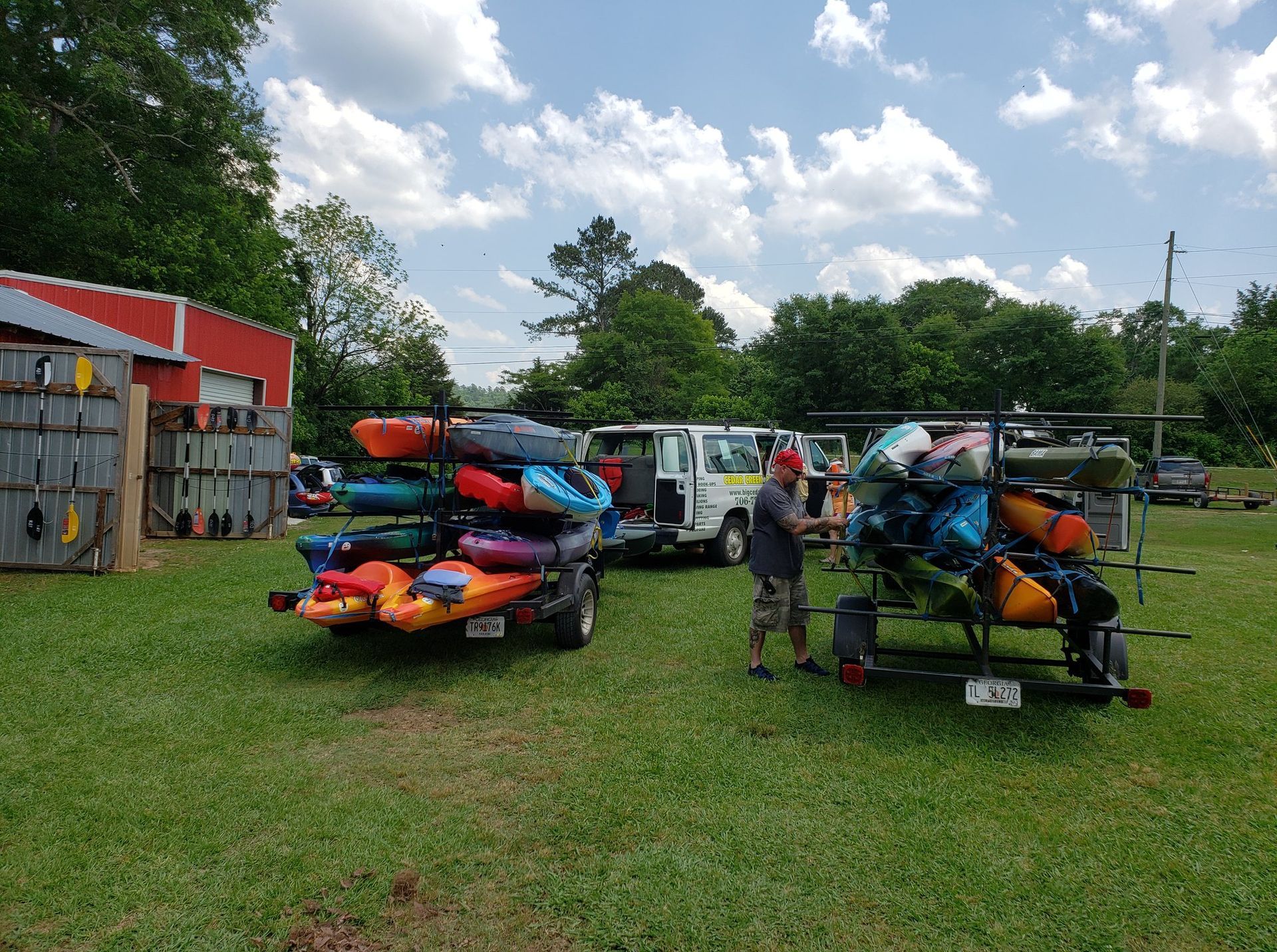 a man is loading kayaks onto a trailer in a field .
