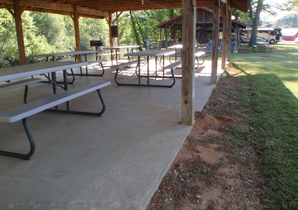 a picnic area with tables and benches under a covered area