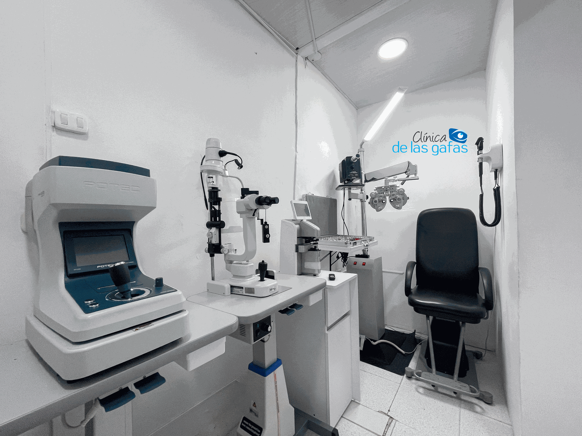 Un consultorio oftalmológico con una silla, una mesa y un microscopio.