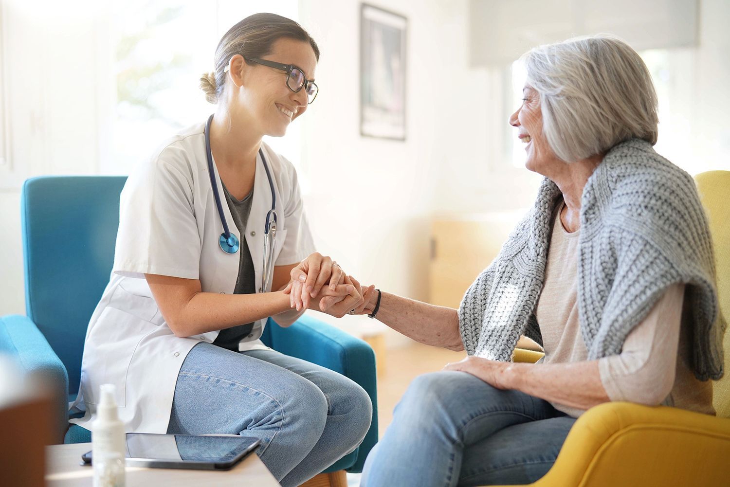 A nurse speaking with an elderly woman, providing guidance on her home health care service options.
