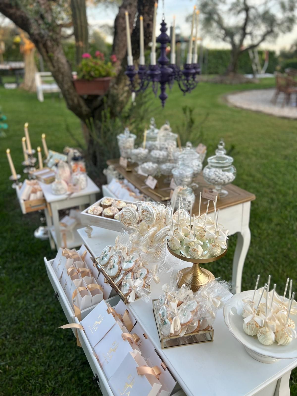 Tavoli da pranzo formali apparecchiati per un ricevimento di nozze con tovaglie bianche, bicchieri e centrotavola floreali.