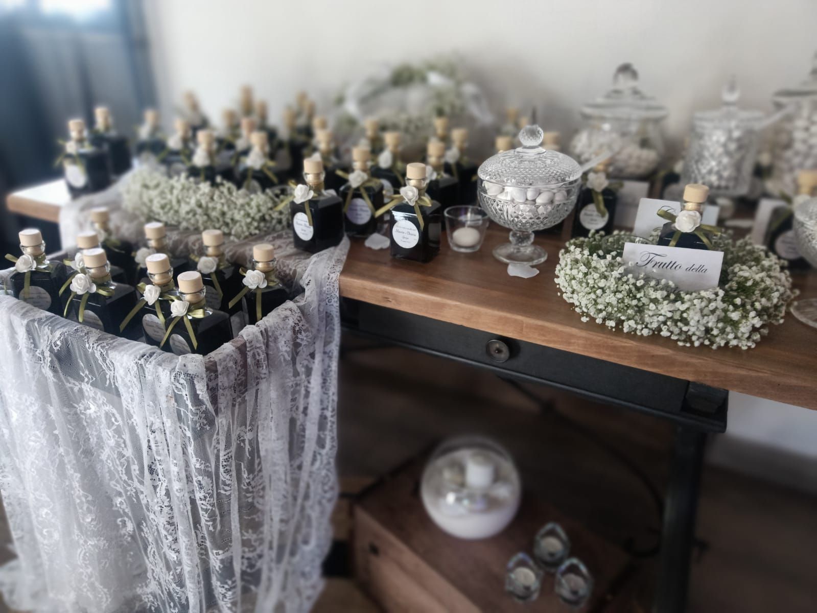 Un tavolo con bomboniere e barattoli di caramelle durante un ricevimento di nozze.