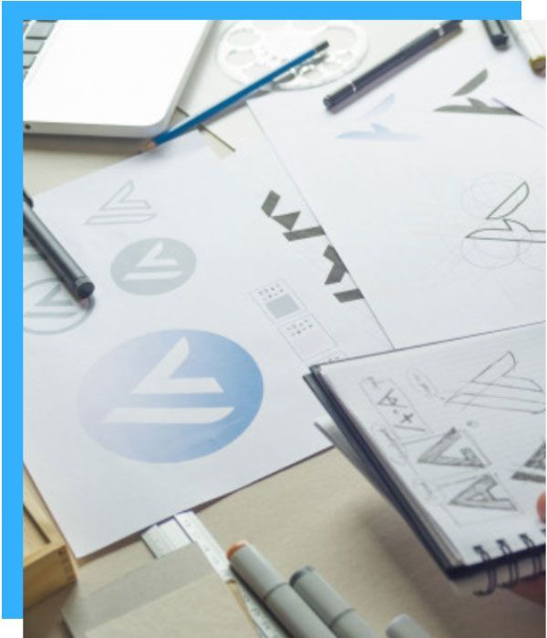 A person is drawing a logo on a piece of paper