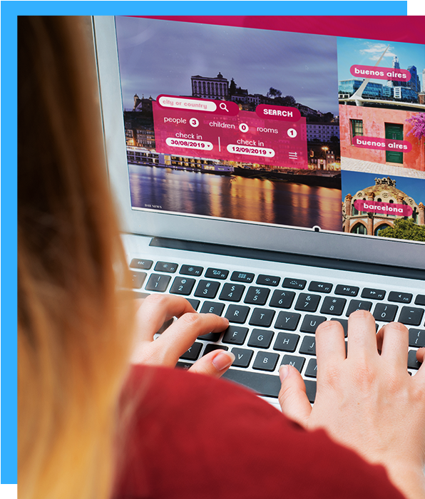 A woman is typing on a laptop with a picture of a city on the screen.