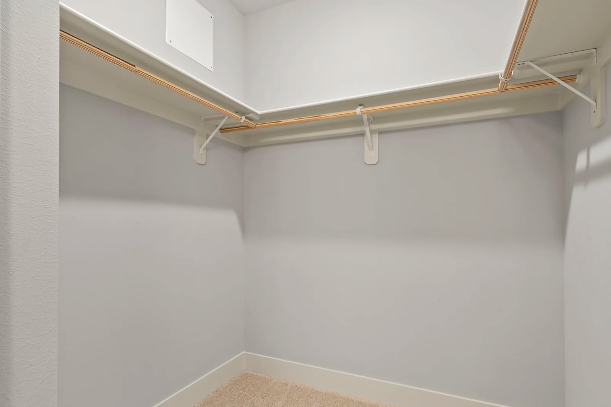Empty white closet with shelves and rod.