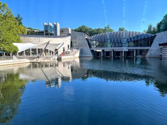 A large building is reflected in a body of water.