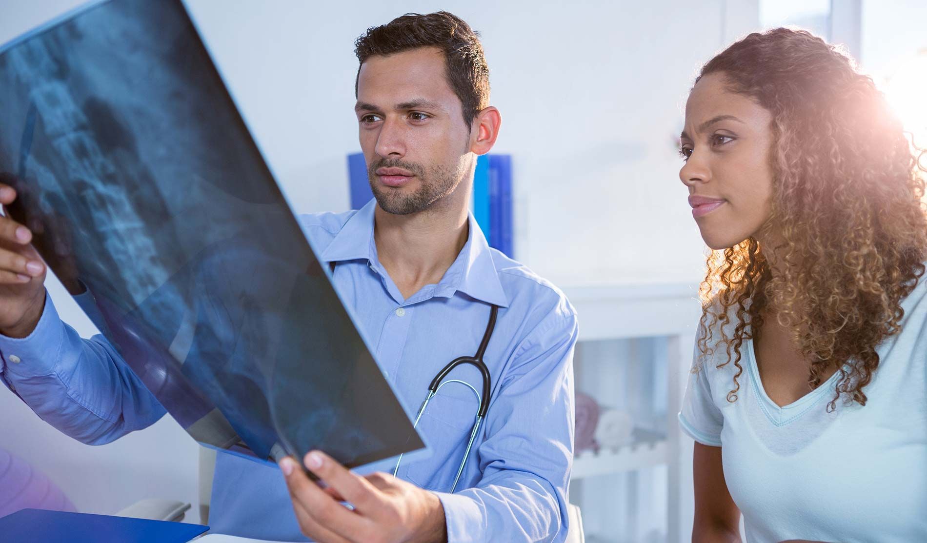 A doctor is looking at an x-ray with a patient.