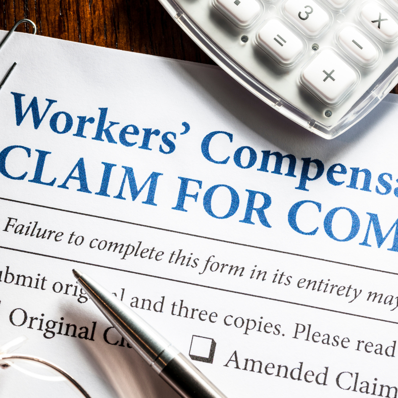 A calculator sits on top of a workers ' compensation claim form