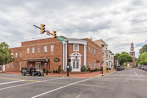 A brick building is sitting on the corner of a city street.