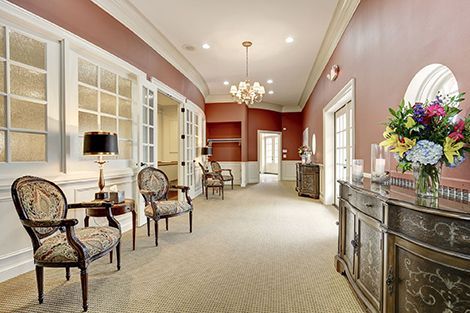 A long hallway with chairs and a vase of flowers