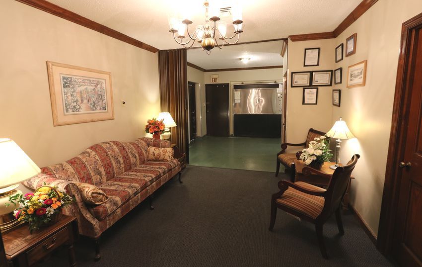 A living room with a couch and chairs and a chandelier