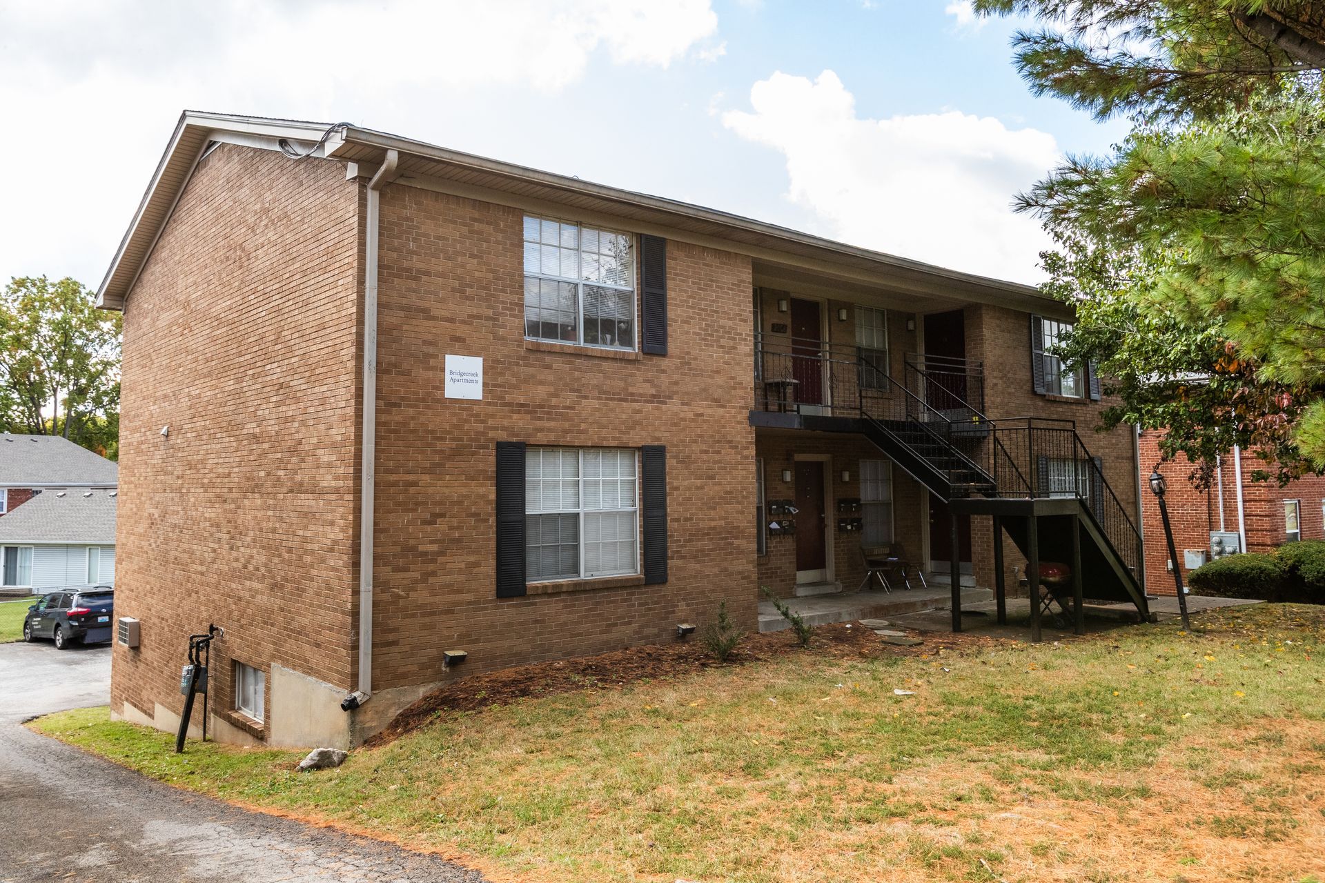 A brick apartment building with stairs leading up to the second floor.