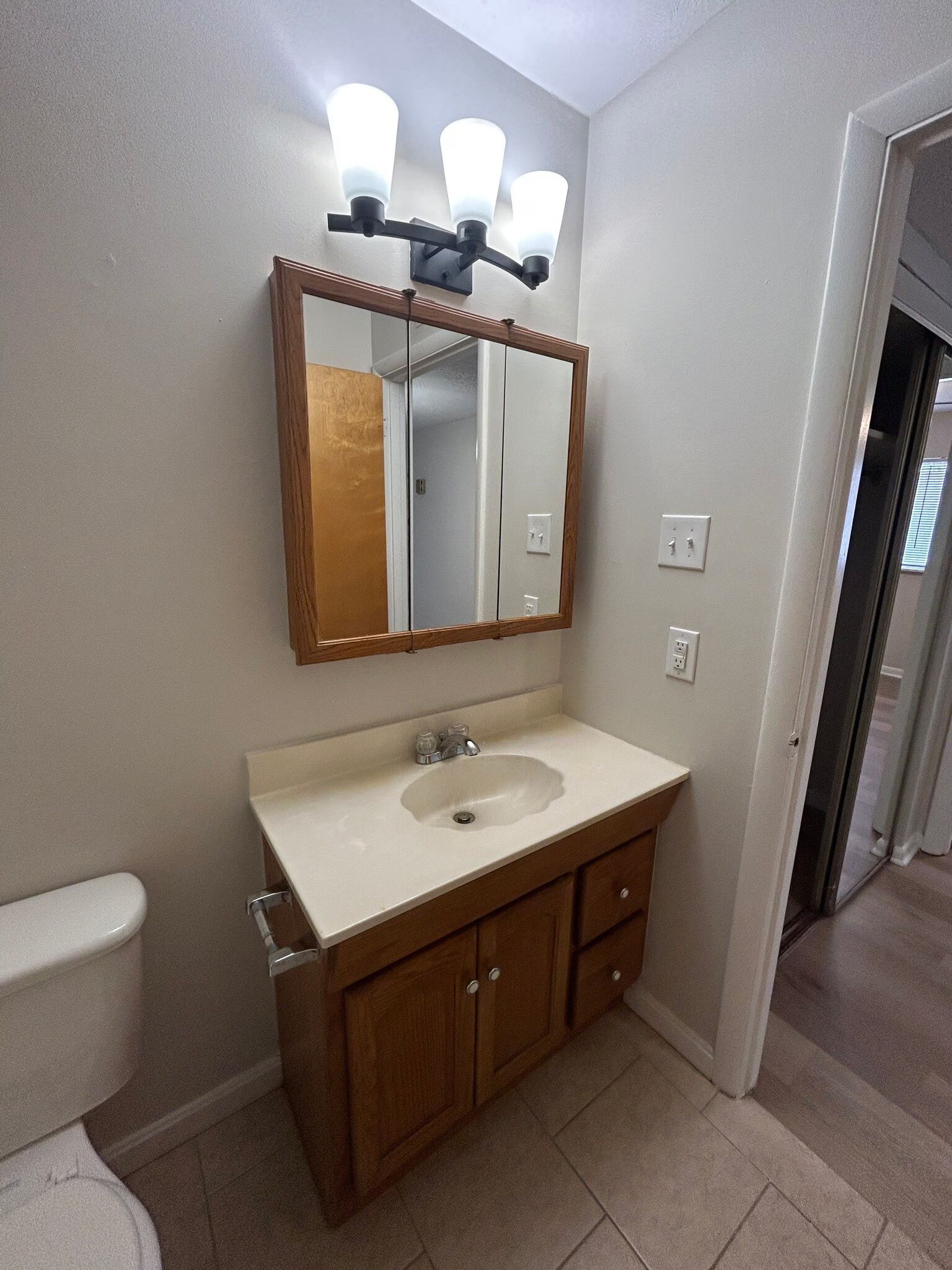 A bathroom with a sink , mirror and toilet.