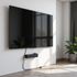 Large TV mounted on a white wall, with a black cable box and plants.