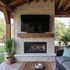 Outdoor stone fireplace with TV, wooden mantel, and seating area.
