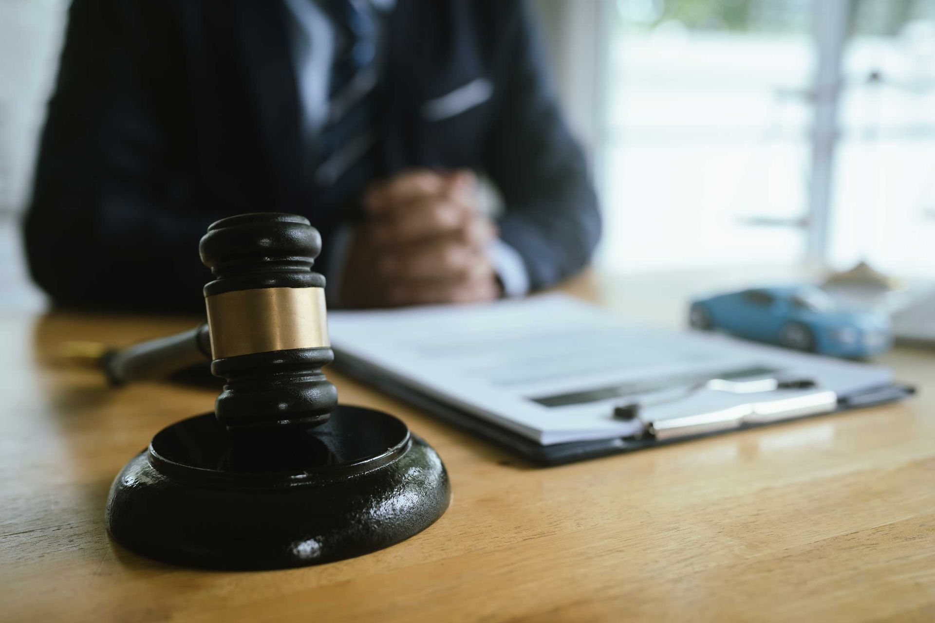 A gavel with a lawyer in the background.