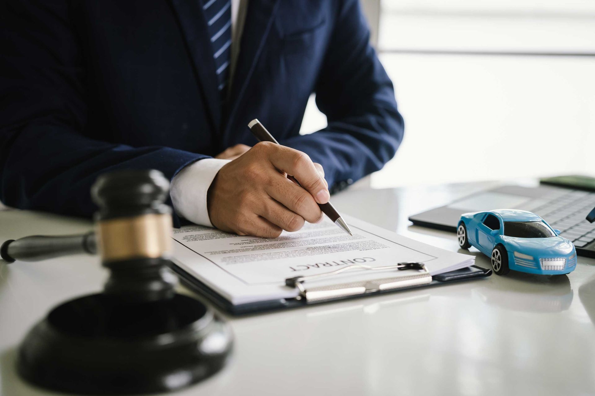 Lawyer signing legal document showcasing motor vehicle accident attorney guidance.