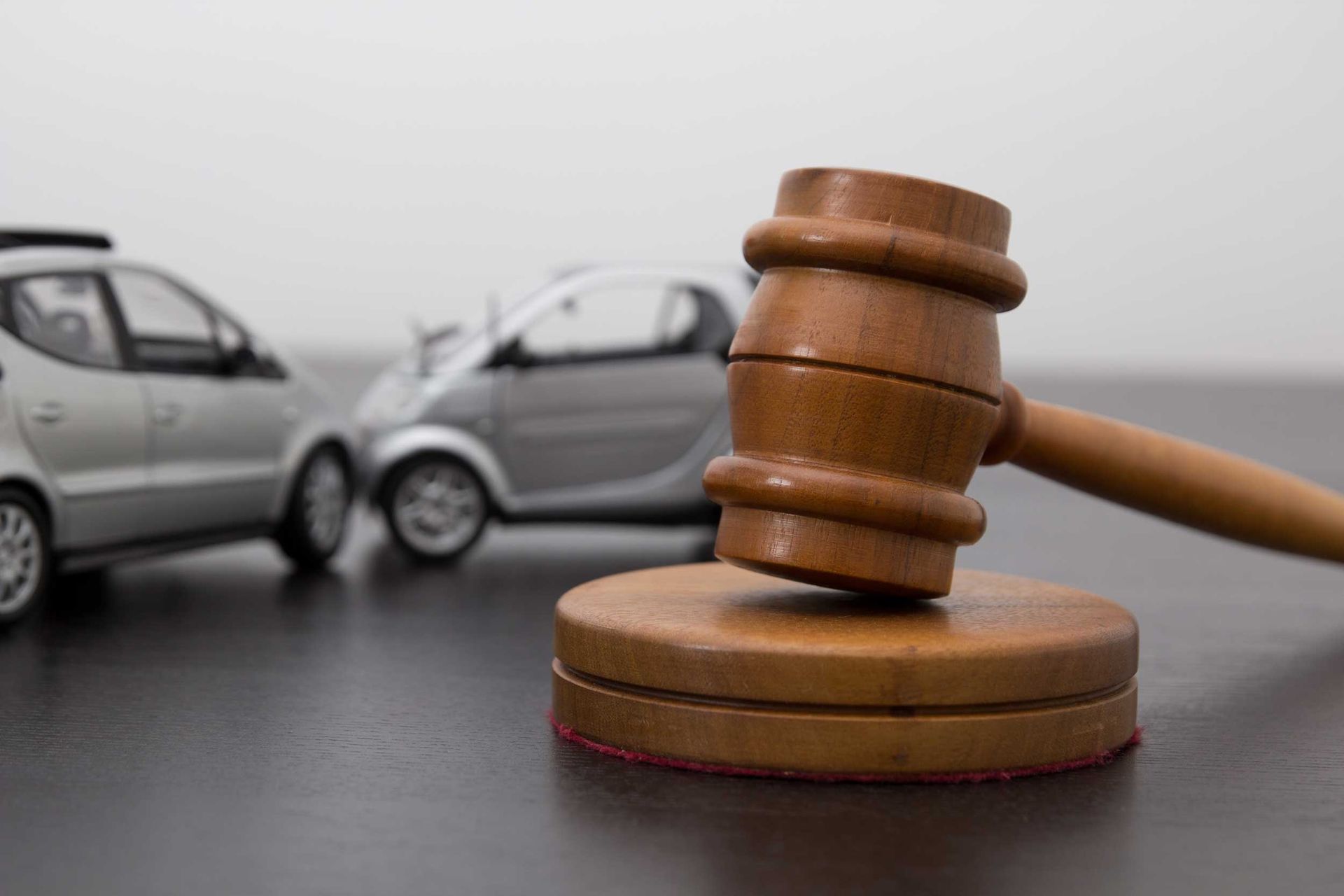 Gavel with model cars, symbolizing car accident legal action by a motor vehicle accident attorney.