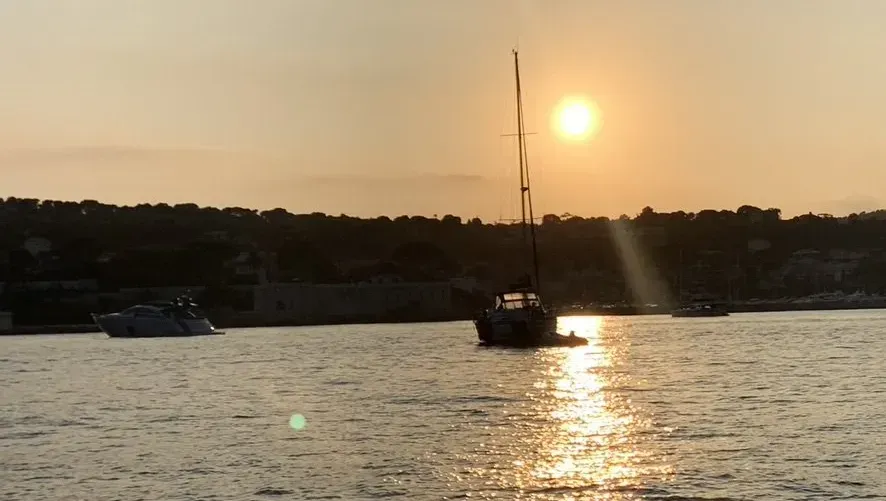 Un voilier flotte dans l'eau au coucher du soleil
