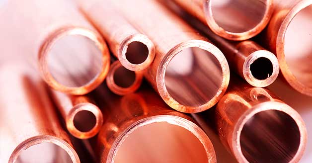 a bunch of copper pipes are stacked on top of each other on a table .