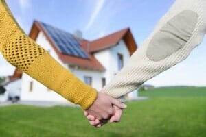 Couple holding hands in front of new home —Attorney in Longmeadow, MA