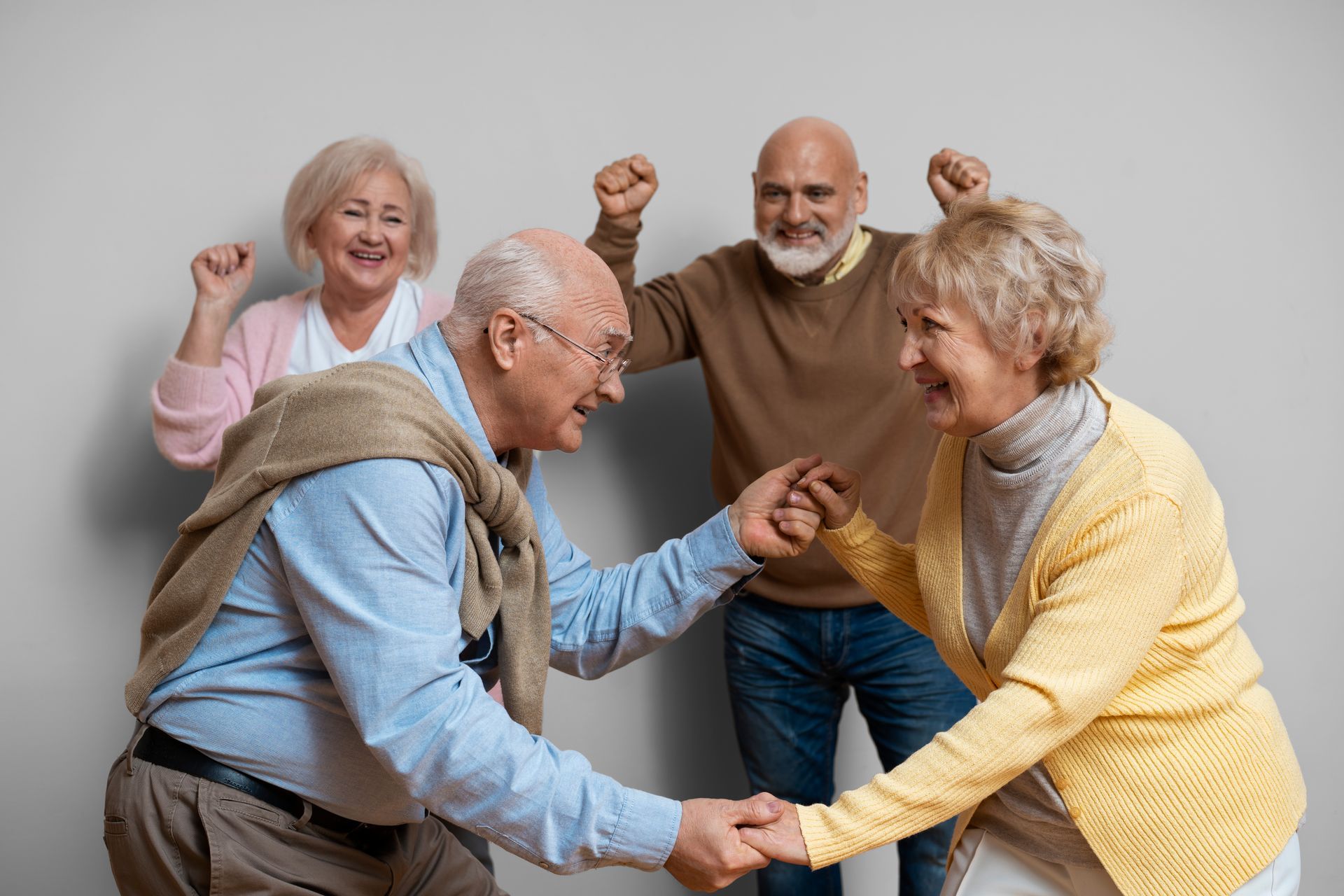 A group of elderly people are dancing together and holding hands.