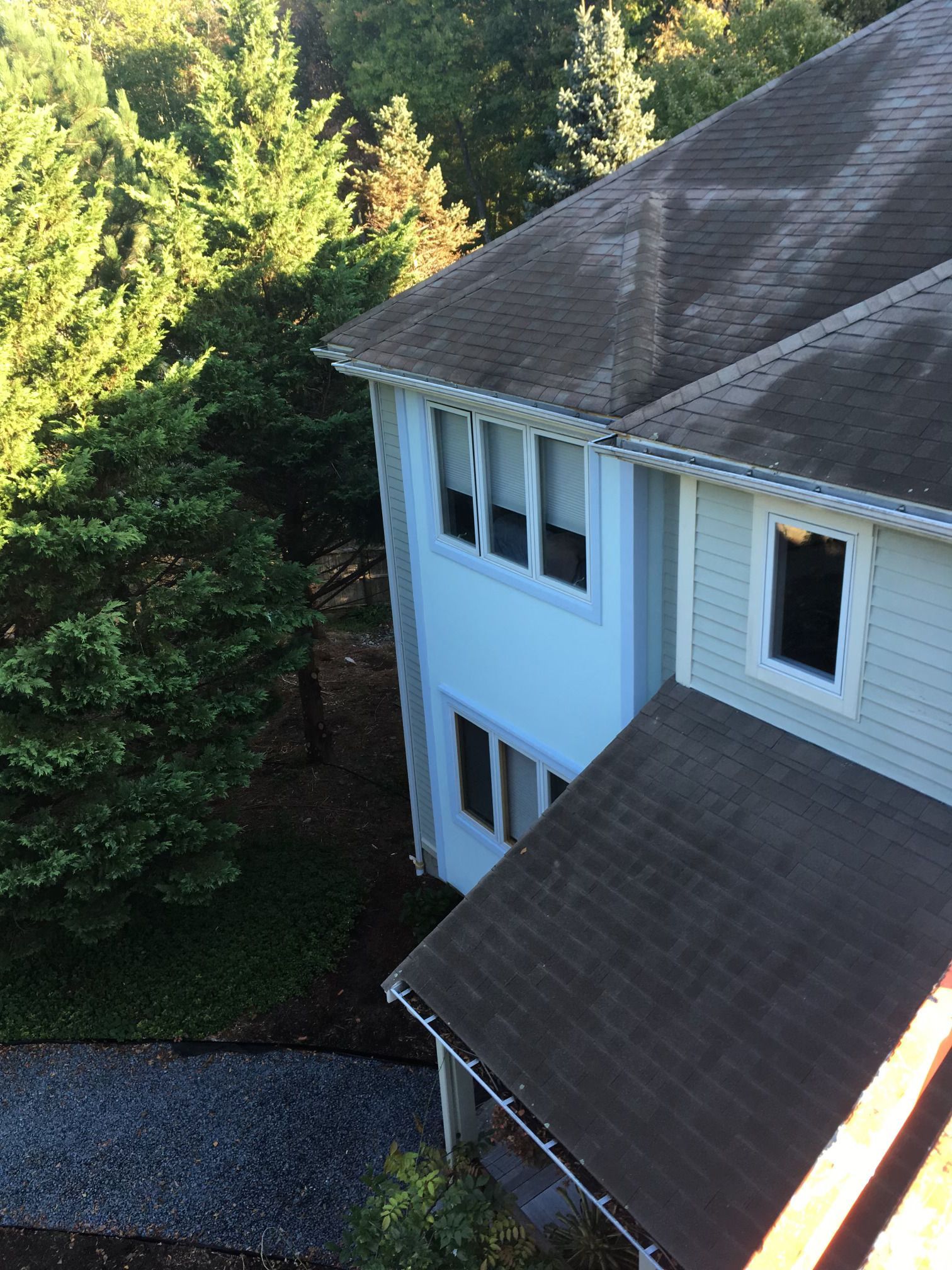 An aerial view of a house with trees in the background.