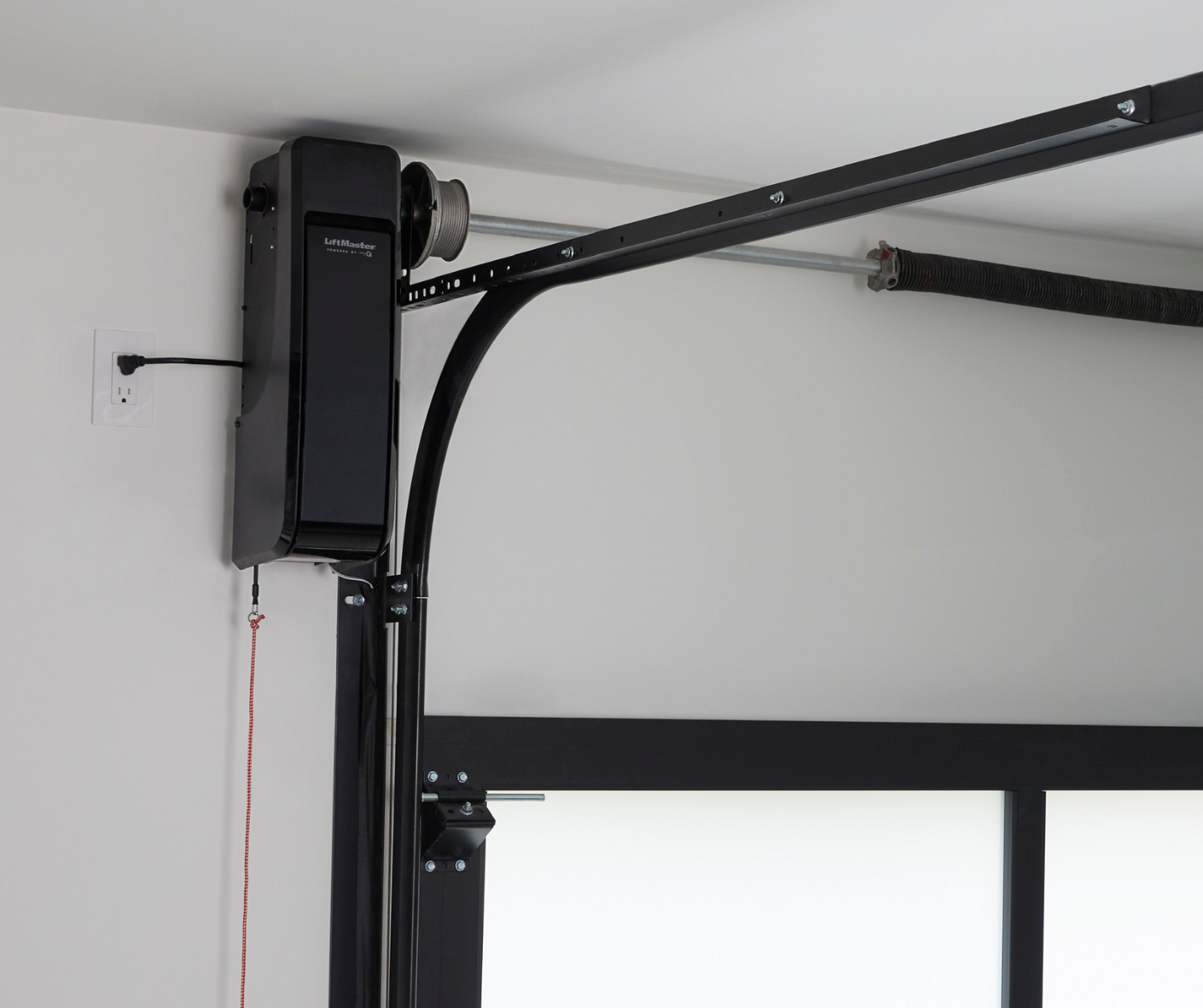 Black garage door opener mounted on white wall.