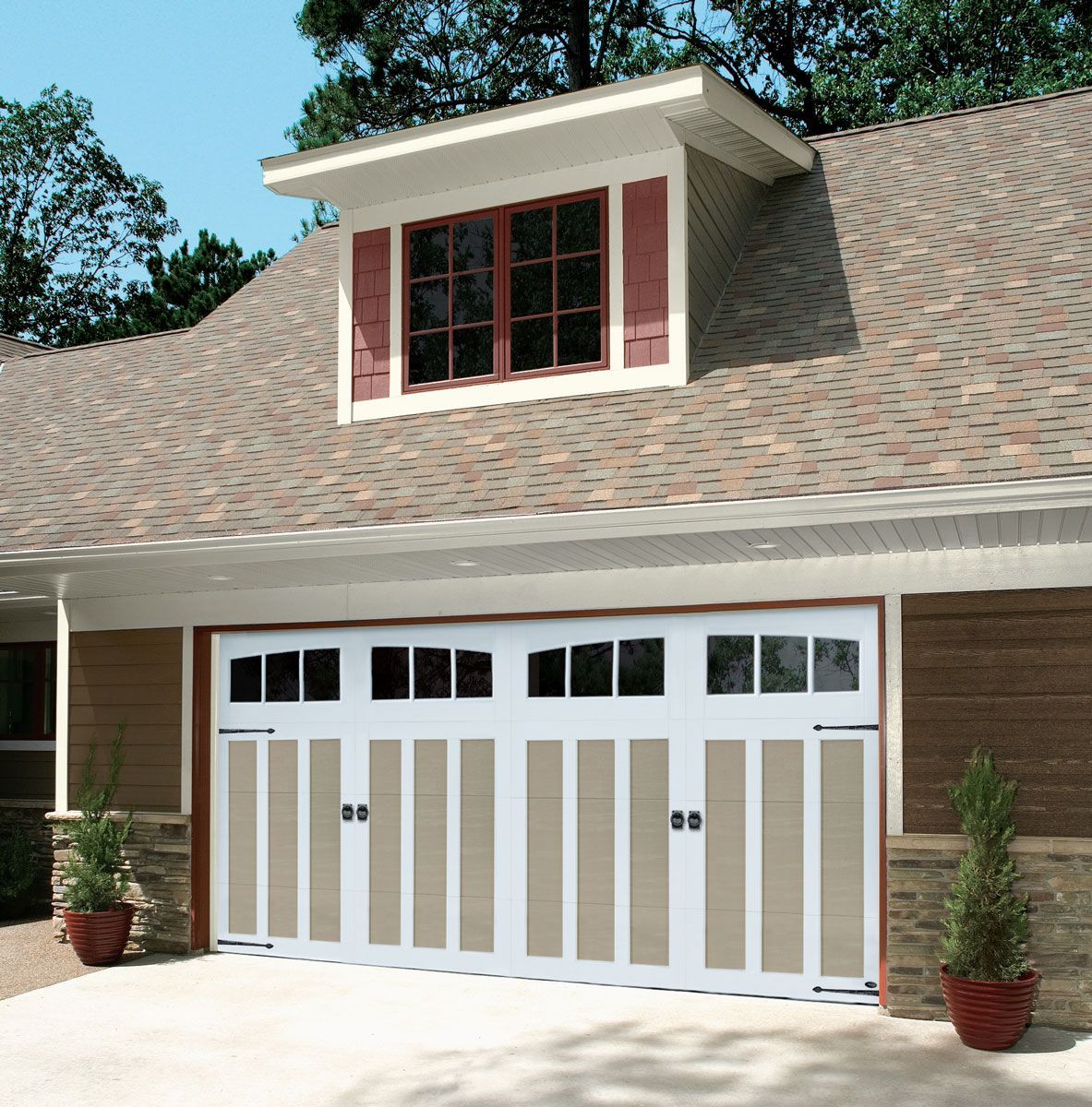A house with a large garage door and a window on the roof