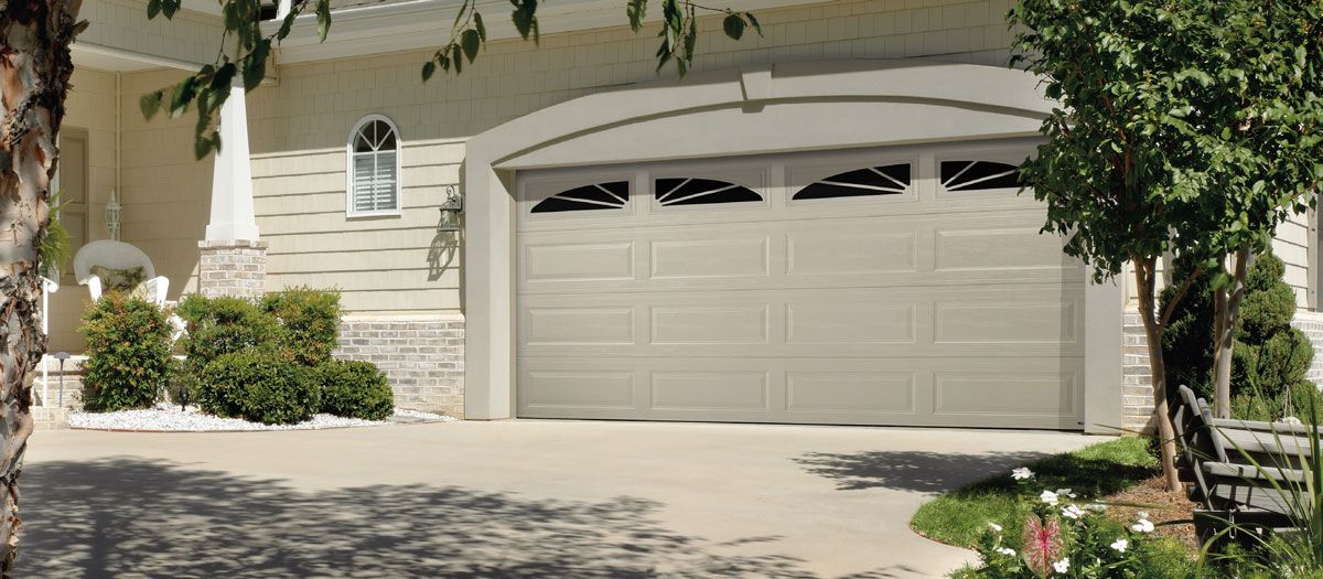 There is a large garage door in front of a house.