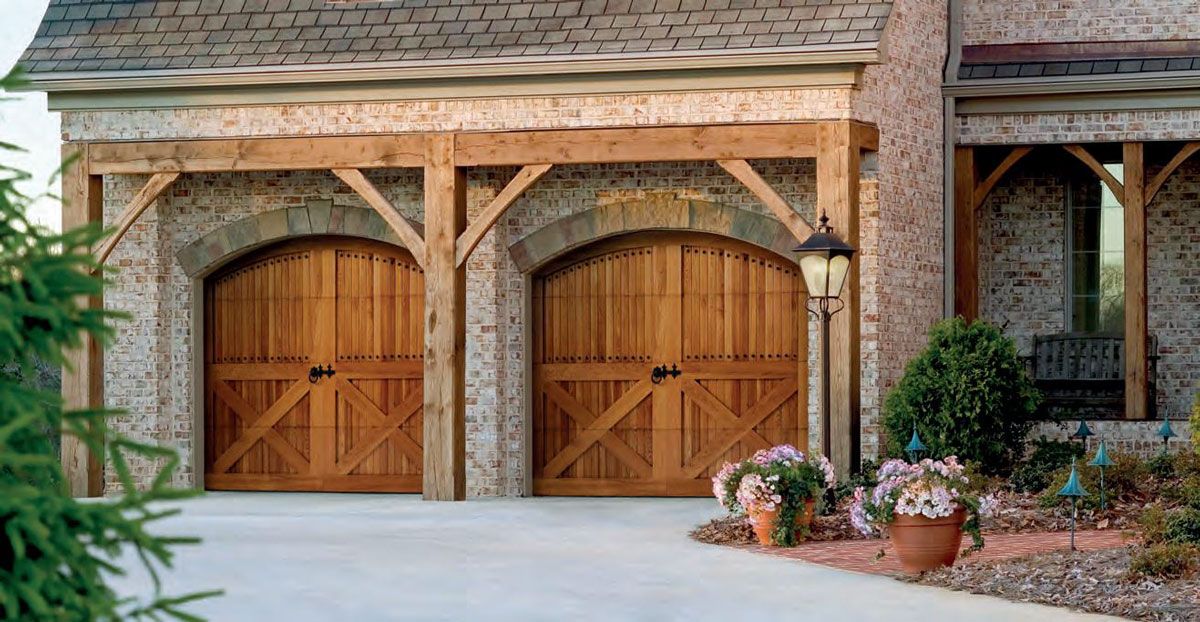 A large brick house with two wooden garage doors