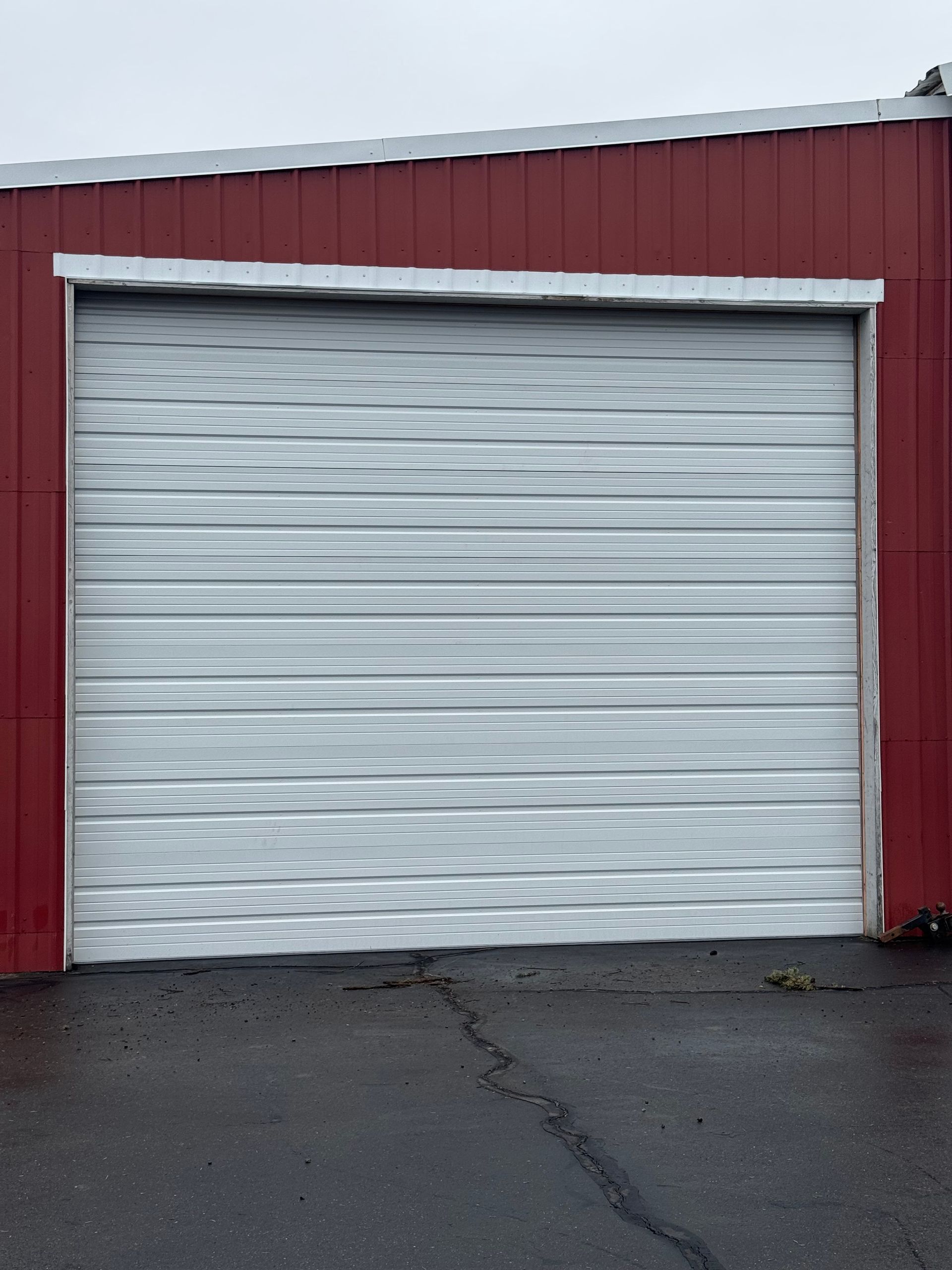 White metal garage door on a red building.