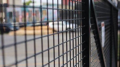 Dark gray horizontal slat gate set in a stone wall.
