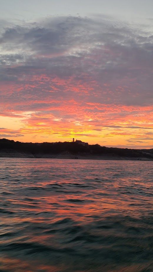 A sunset viewed from a pontoon boat on our sunset cruise on Lake Travis in Austin Texas TX