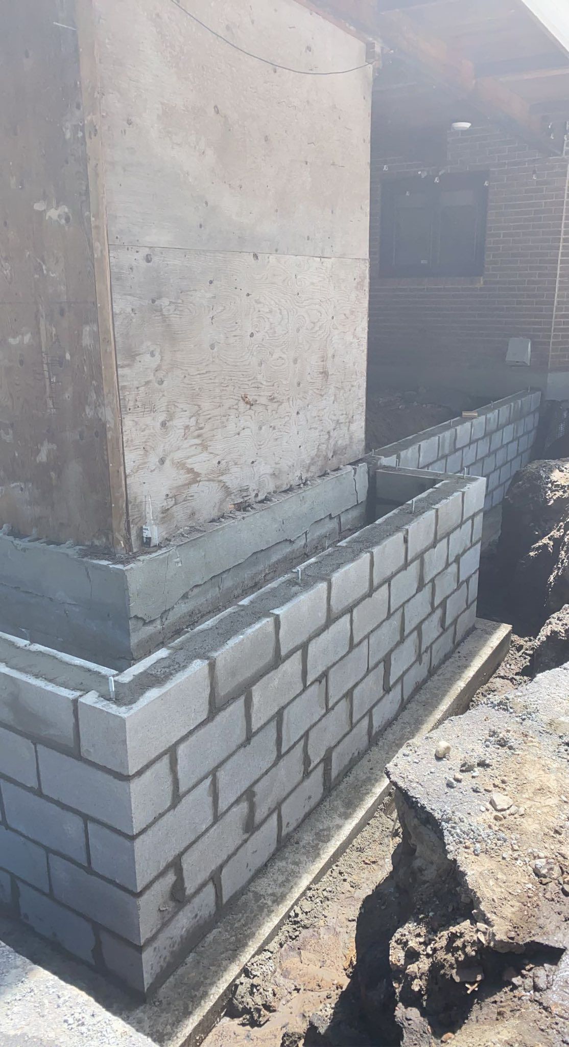 Fondation en parpaings gris en cours de construction à la base d'un bâtiment.