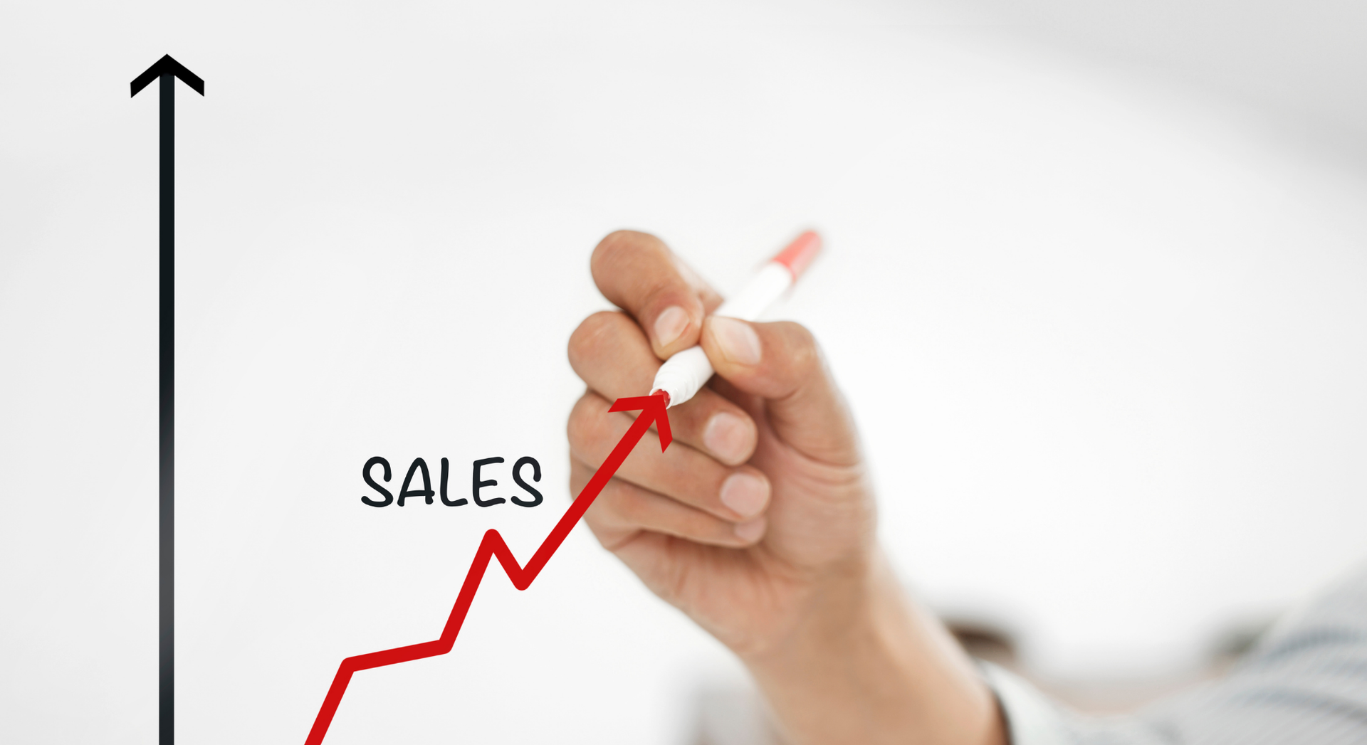 Hand drawing a red upward trending sales graph.
