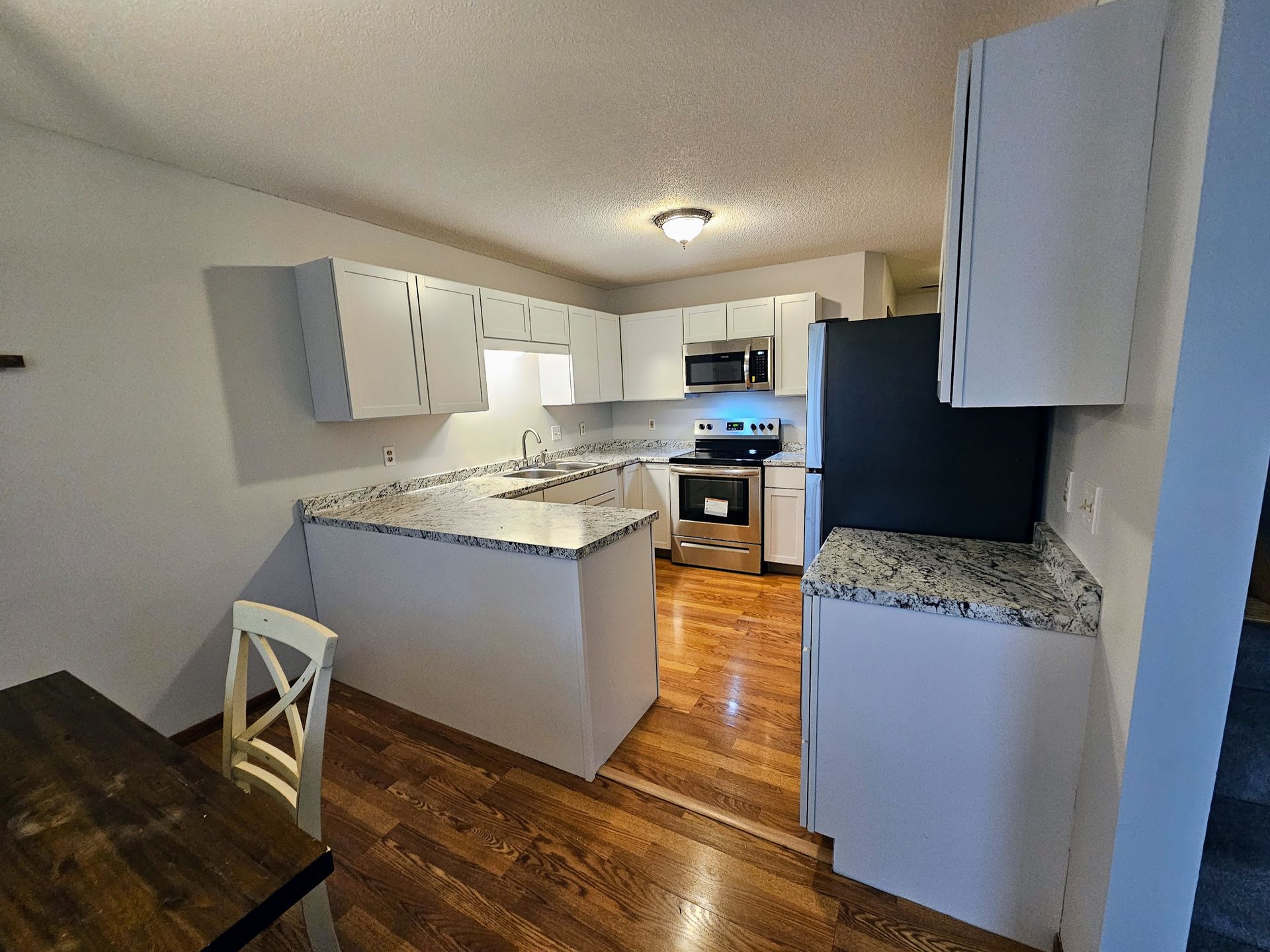 A kitchen with a cutting board and glasses on a shelf