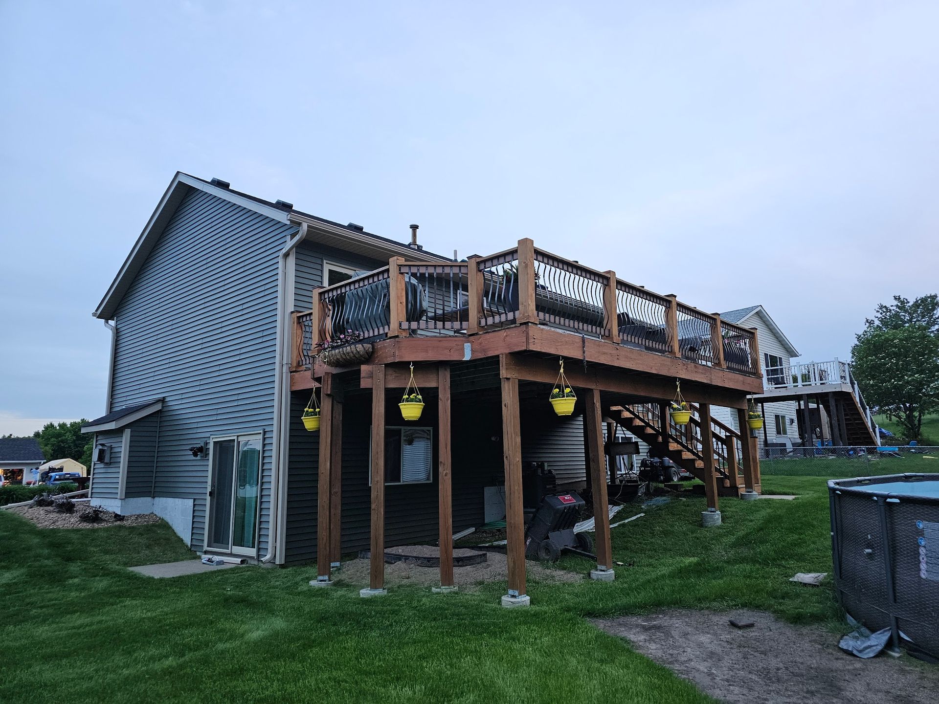 A table with a vase of flowers on it is on a deck overlooking a body of water.