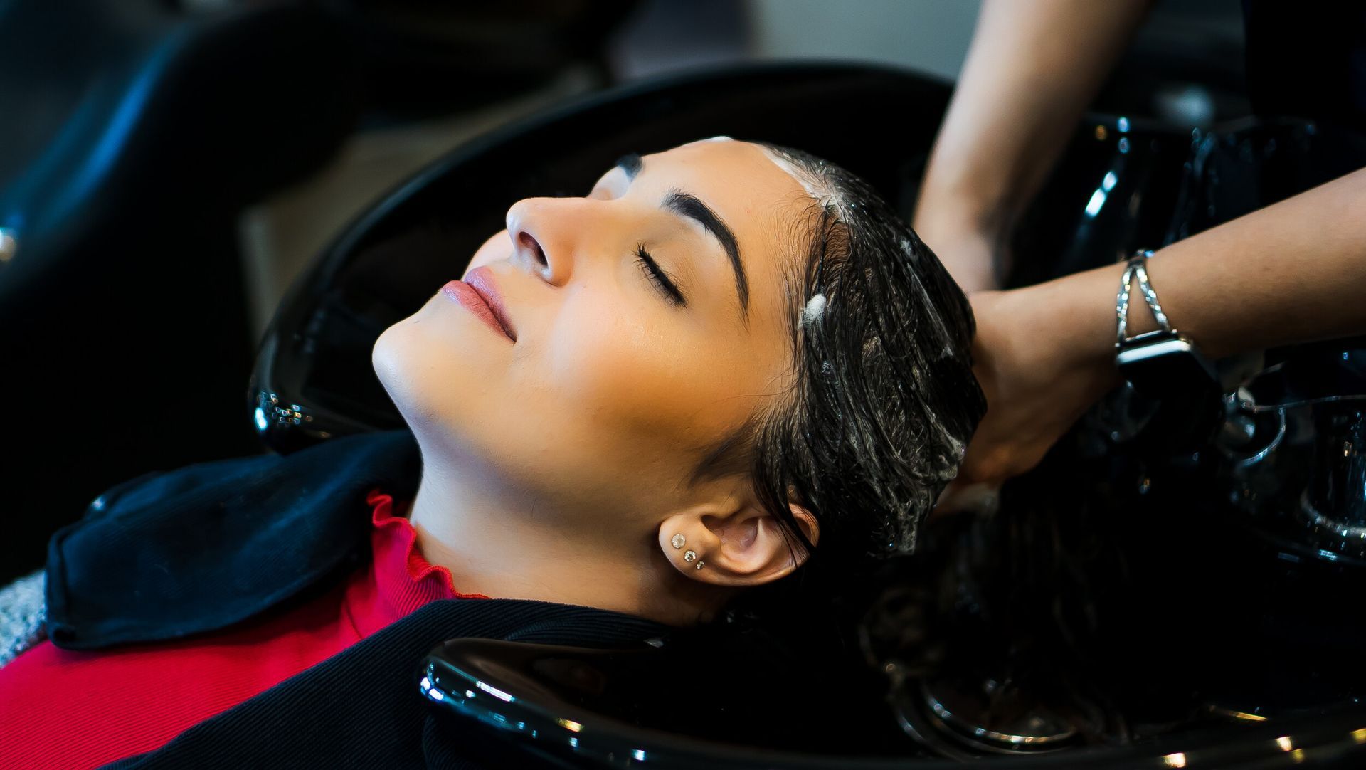 A woman is getting her hair washed at a salon.