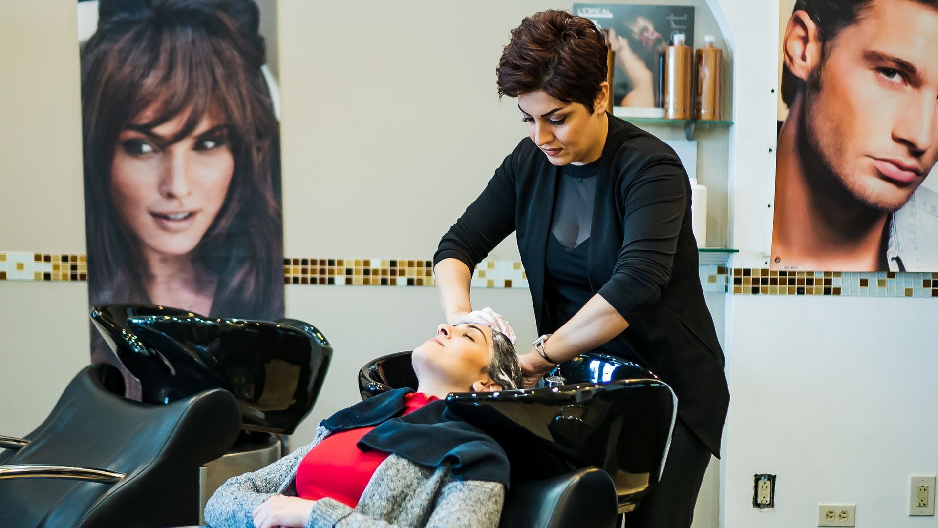 A woman is getting her hair washed at a hair salon.