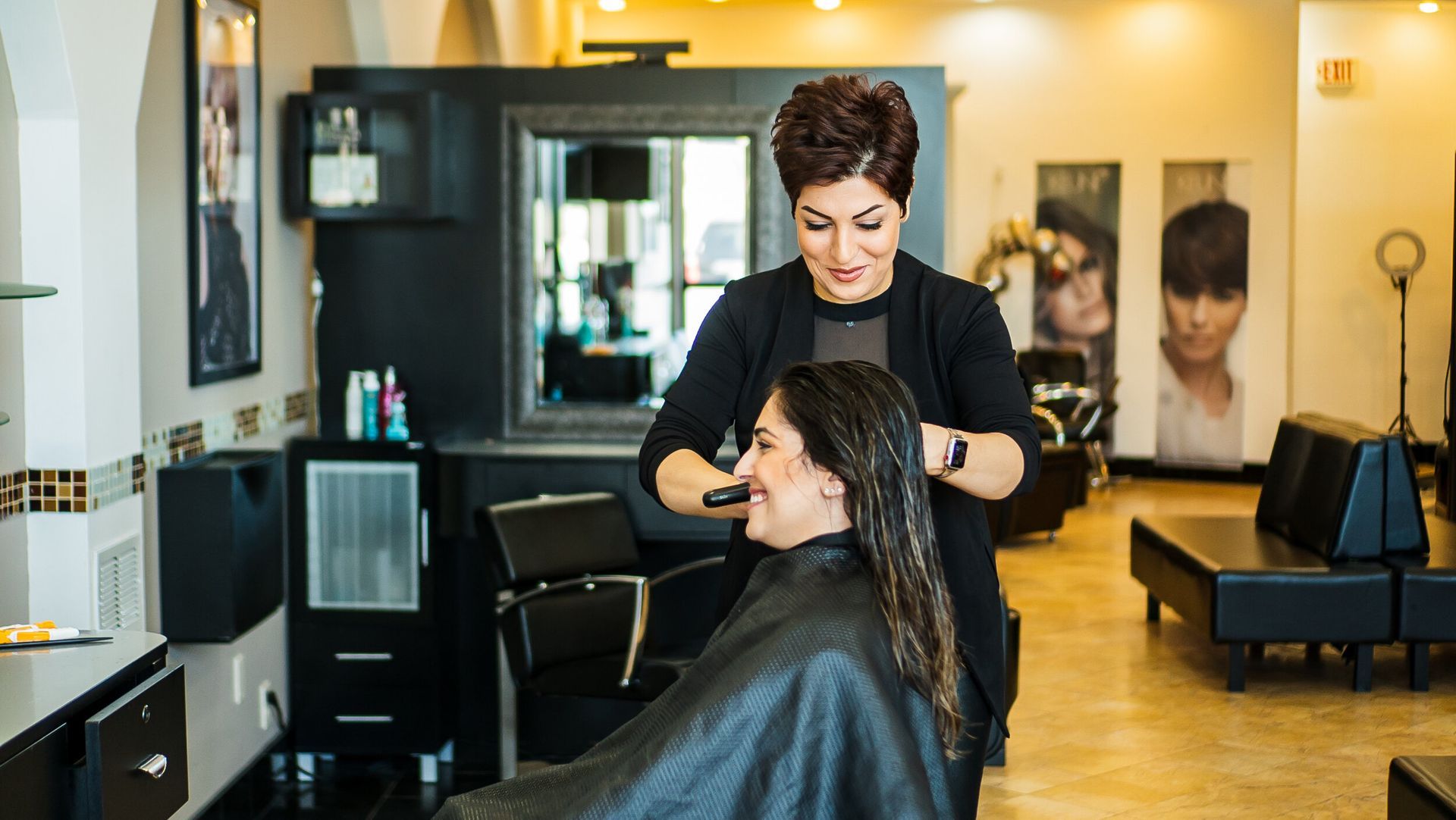 A woman is getting her hair cut by a hairdresser in a salon.