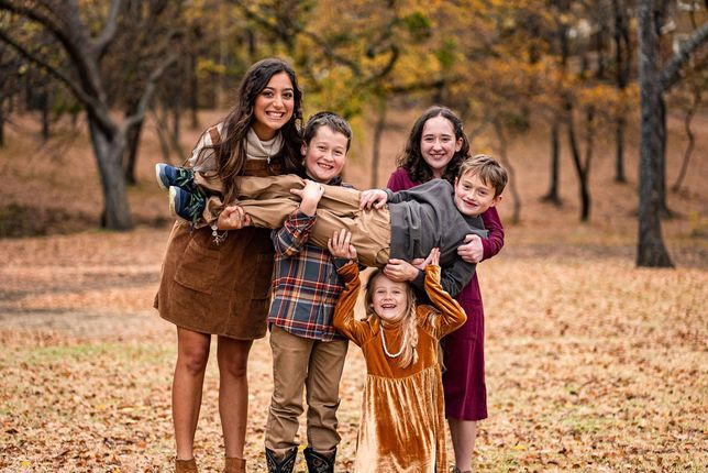 A family is posing for a picture in the woods.