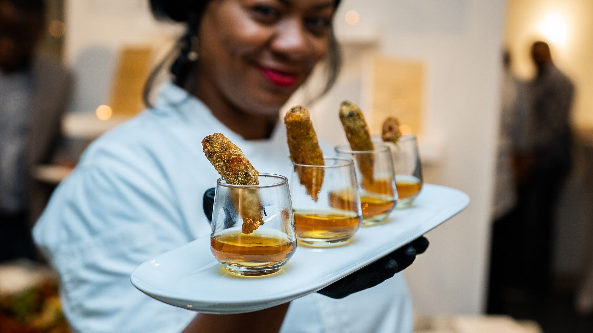 A woman is holding a tray of food and drinks.
