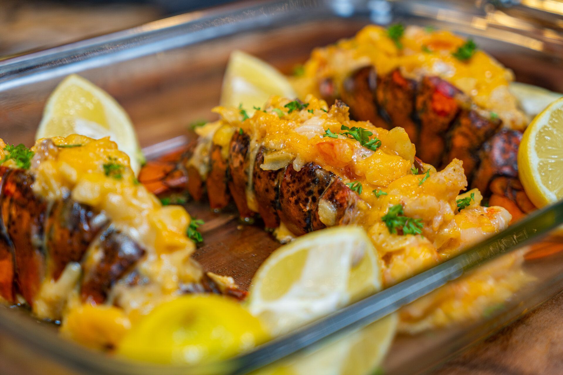 A casserole dish filled with lobster tails and lemon slices.