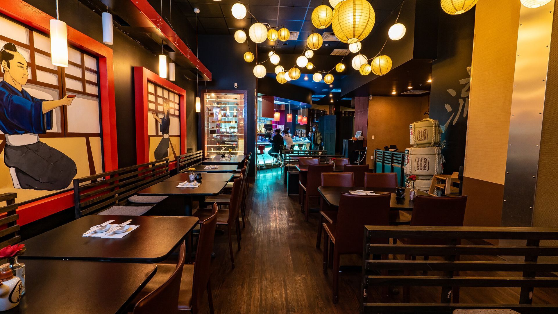 A restaurant with tables and chairs and a painting on the wall.