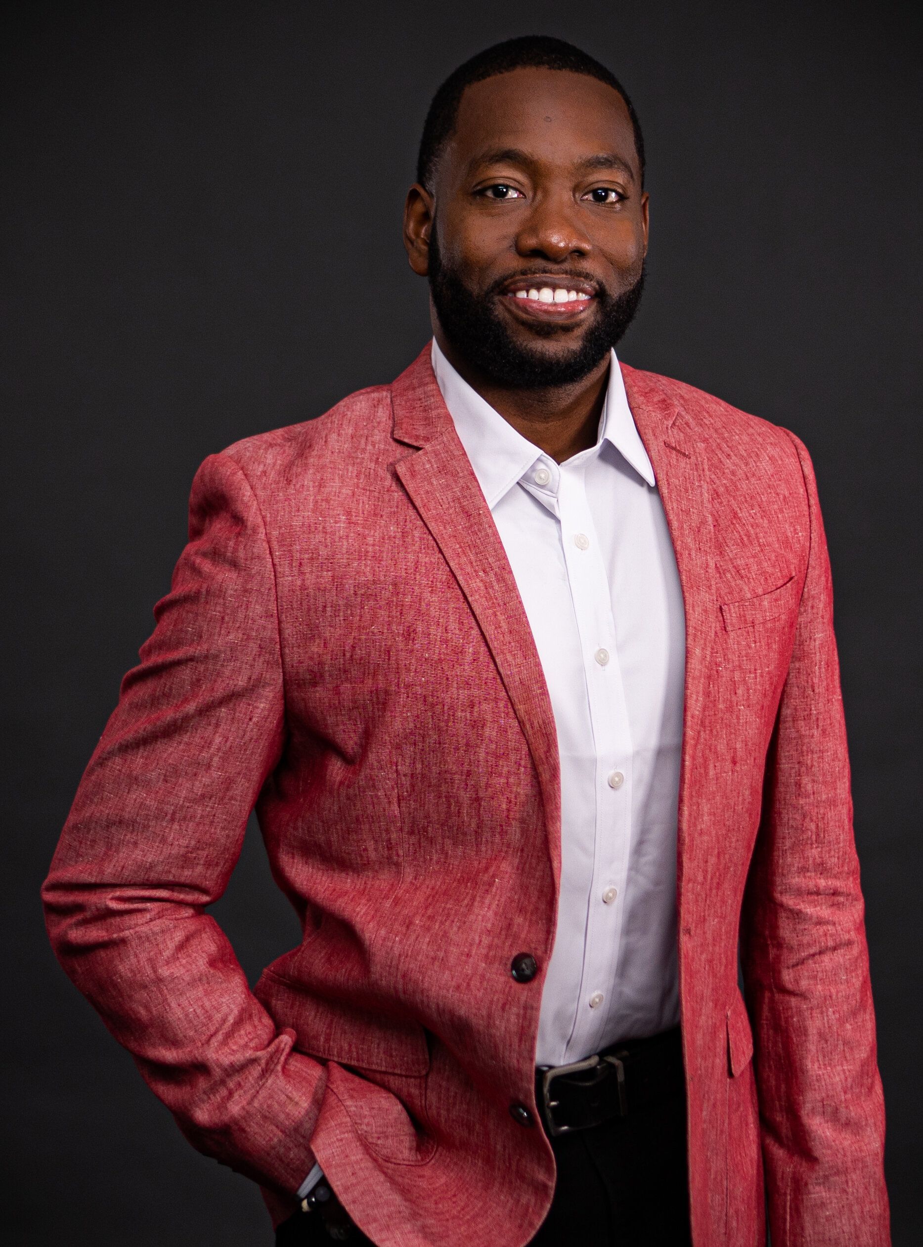 A man is wearing a red jacket and a white shirt.