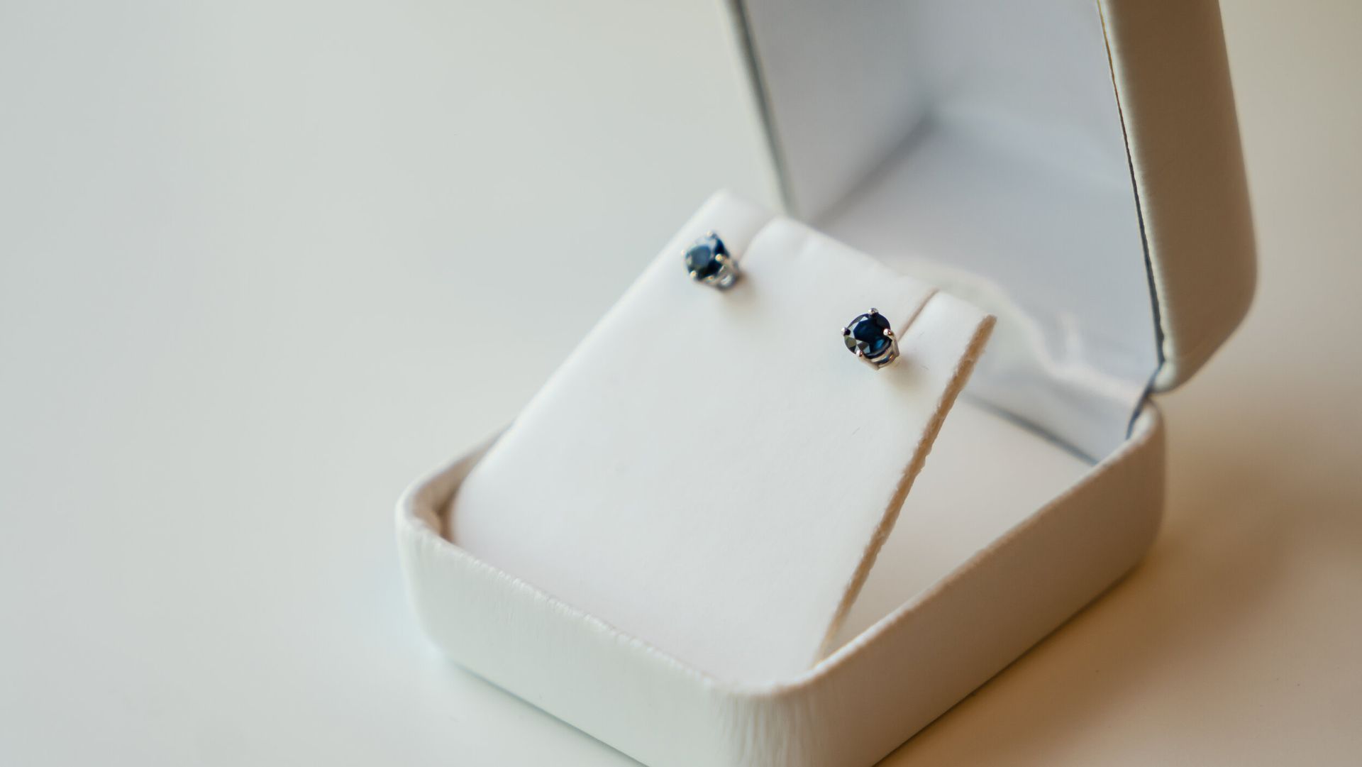 A pair of stud earrings in a white box